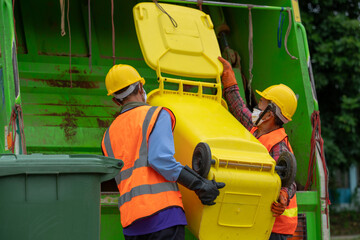 Garbage collectors teamwork and wear uniforms.