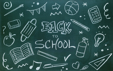 Blackboard written with chalk with message, school supplies and coronavirus protections. Back to school concept