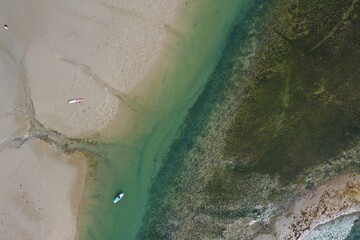 aerial view of a lone kayak or canoe on a calm turquoise ocean river