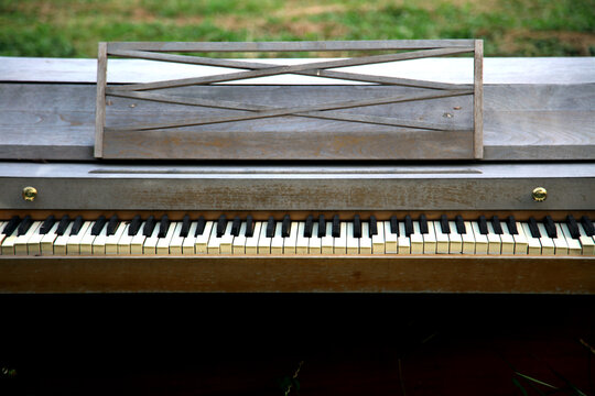 Weathered piano, in a field. 