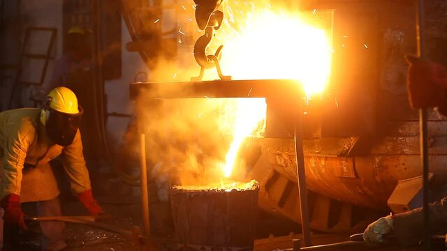 Trabalho &aacute;rduo em uma fundi&ccedil;&atilde;o. Forno de fus&atilde;o de metal em usina sider&uacute;rgica. Vazamento de metal fundido, metalurgia, fundi&ccedil;&atilde;o de a&ccedil;o. Fabrica&ccedil;&atilde;o de a&ccedil;o