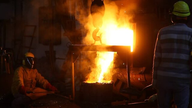 Trabalho &aacute;rduo em uma fundi&ccedil;&atilde;o. Forno de fus&atilde;o de metal em usina sider&uacute;rgica. Vazamento de metal fundido, metalurgia, fundi&ccedil;&atilde;o de a&ccedil;o. Fabrica&ccedil;&atilde;o de a&ccedil;o