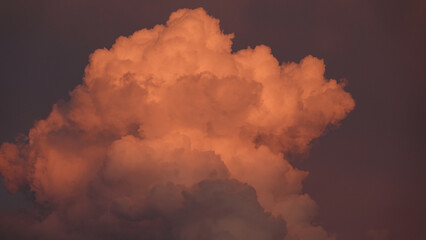 Masses of clouds hanging in the sky in red and white and crimson hues	, hurricane