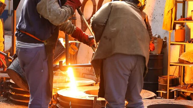 Trabalho &aacute;rduo em uma fundi&ccedil;&atilde;o. Forno de fus&atilde;o de metal em usina sider&uacute;rgica. Vazamento de metal fundido, metalurgia, fundi&ccedil;&atilde;o de a&ccedil;o. Fabrica&ccedil;&atilde;o de a&ccedil;o