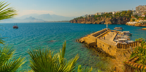 ANTALYA, TURKEY: Ship with tourists sails along the Mediterranean coast on a sunny summer day in Antalya.