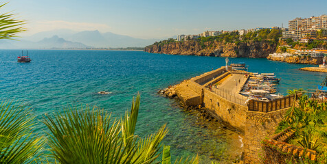 Obraz premium ANTALYA, TURKEY: Ship with tourists sails along the Mediterranean coast on a sunny summer day in Antalya.