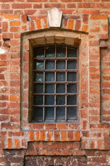 Fototapeta na wymiar medieval window with bars in a brick wall