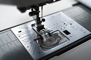 Close-up of modern sewing machine foot. Selective focus on numbers near machine foot.