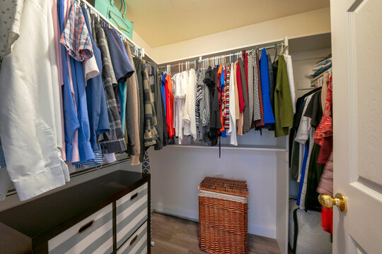 Walk in closet with an open wardrobe with metal rods