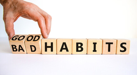 Good or bad habits symbol. Businessman turns wooden cubes and changes words 'bad habits' to 'good habits'. Beautiful white table, white background. Business, bad or good habits concept. Copy space.