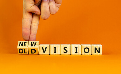 New or old vision symbol. Businessman turns cubes and changes words 'old vision' to 'new vision'. Beautiful orange table, orange background, copy space. Business, old or new vision concept.