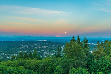 Simultaneous sunset and moonrise over Mount Baker as seen across Fraser Valley from Burnaby Mountain