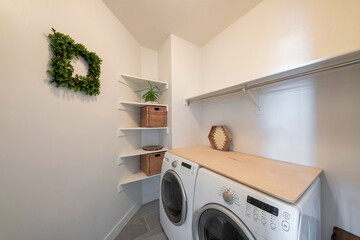 Small minimalist laundry room with wall mounted corner shelves - obrazy, fototapety, plakaty