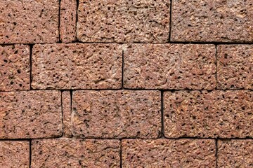 Brown laterite stone wall outside the building at the ancient site