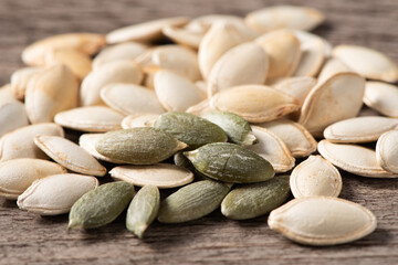 Dry pumpkin seeds on wooden table.