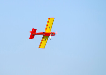 red and yellow model airplane in flight