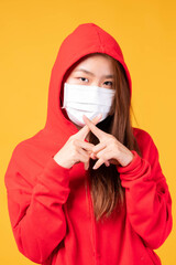 Asian hoodies girl wearing protective face mask for protection during the quarantine Coronavirus covid19 outbreak on yellow background , protect spread Covid-19 and pm2.5 air pollution