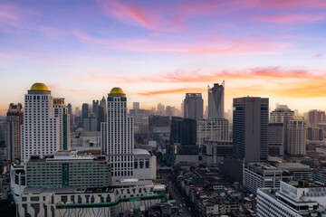 Fototapeta premium Aerial view modern office buildings in Bangkok city downtown with sunset time