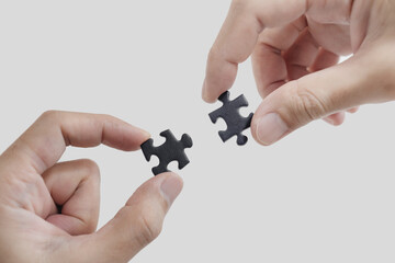 Close-up hands connecting jigsaw puzzle