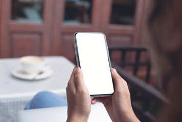 Cell phone mockup image blank white screen.  Woman hand holding, using mobile phone at home.