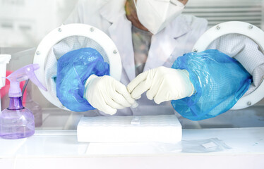 Close up to the rubber gloves on the asian medical staff is processing coronavirus or covid-19 test...