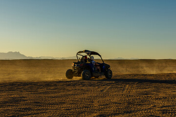 Unrecognizable people driving buggy during safari trip at sunset in Arabian desert not far from the Hurghada city, Egypt