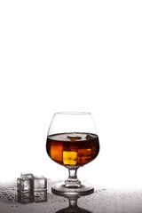 Scotch whiskey with ice in glass on table white background
