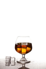 Scotch whiskey with ice in glass on table white background