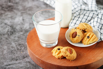 Fresh milk in a glass and almond cookies on the dining table