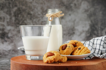 Fresh milk in a glass and almond cookies on the dining table
