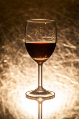 Red wine in glass on a gold background.