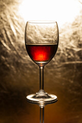 Red wine in glass on a gold background.