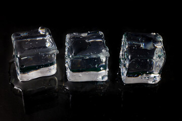 Shining ice cubes on black background.