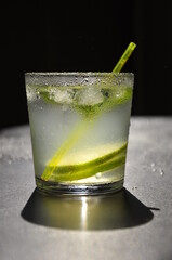 Natural juice with ice and lime on a black background.