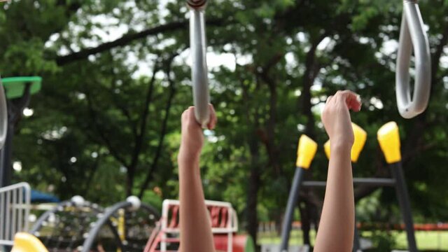 Child's hand grabbing a monkey bar at a playground concept holding on strong preventing falling and maintaining balance.