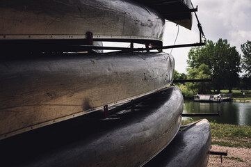 Aluminum canoes stacked on a trailer with a beach front and open water in the background
