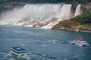 Fototapeta premium Sightseeing tour boats are shown next to the American Falls as seen from Niagara Falls, Ontario, Canada.