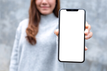 Closeup image mockup image of a beautiful woman holding and showing mobile phone with blank white...