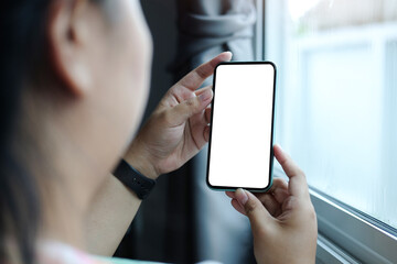 Close up view of businesswoman holding mock up smart phone with blank screen..