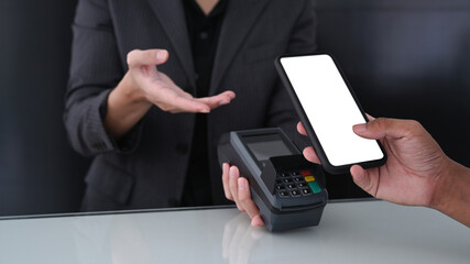 Cropped shot customer paying bill through smart phone.