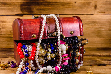 Old box of red wood full of the jewelry. Treasure chest