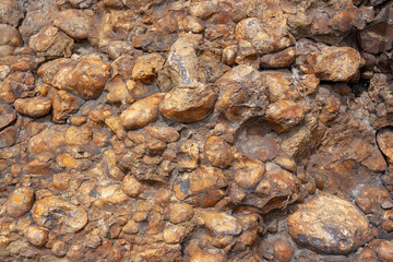 Texture of rock of brown smooth stones similar to concrete. Horizontal image.