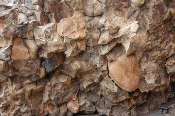 The texture of cracked rock consisting of various small stones. Horizontal image.