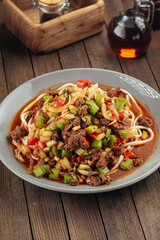 Asian uyghur dish suiru lagman noodles on a wooden background