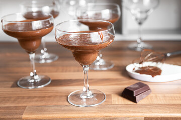 Bowls with chocolate mousse and a piece of dark chocolate on the countertop of a Scandinavian-style kitchen