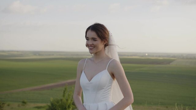 Smiling bride in white dress, slow wind