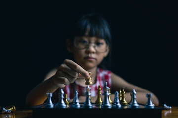 young child playing chess board game for strategy and intelligance game concept. 