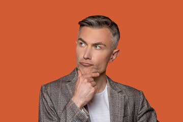 Pensive man touching chin with his hand