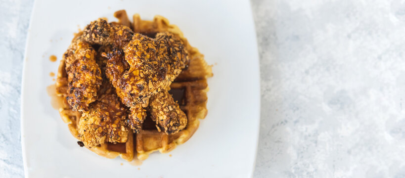 Overhead View Of A White Plate With Fried Chicken And Waffles