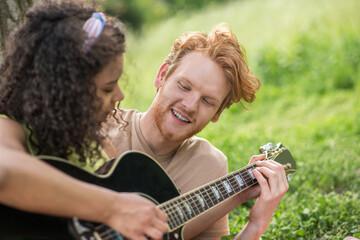 Young happy guy and girl with guitar